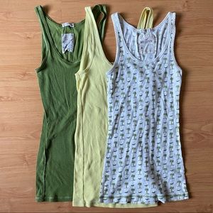 3 Hollister tank tops in green, yellow, and white